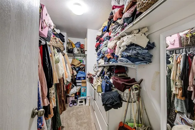 a view of walk in closet with clothes
