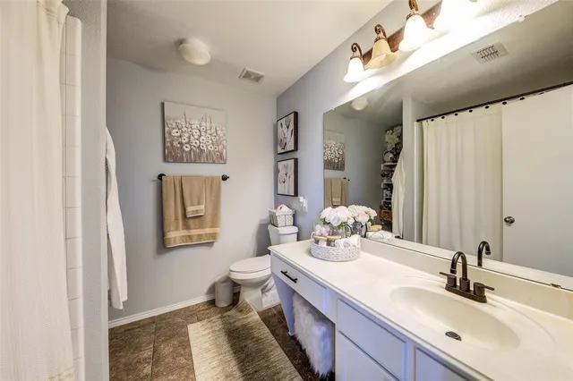 a bathroom with a double vanity sink mirror and toilet