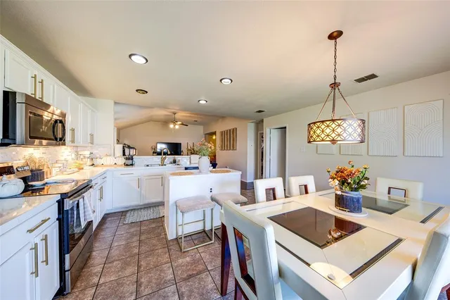 a kitchen that has a lot of cabinets in it and appliances