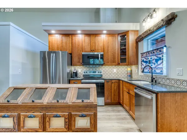 a kitchen with granite countertop a sink stove and refrigerator
