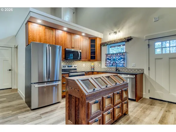 a kitchen with stainless steel appliances granite countertop a refrigerator a sink and a stove