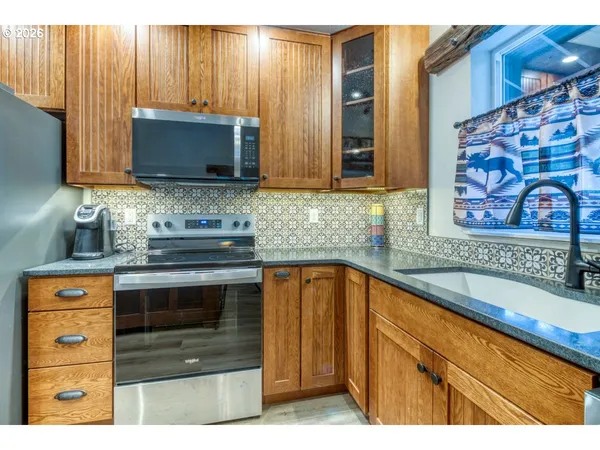 a kitchen with stainless steel appliances granite countertop a sink stove and microwave