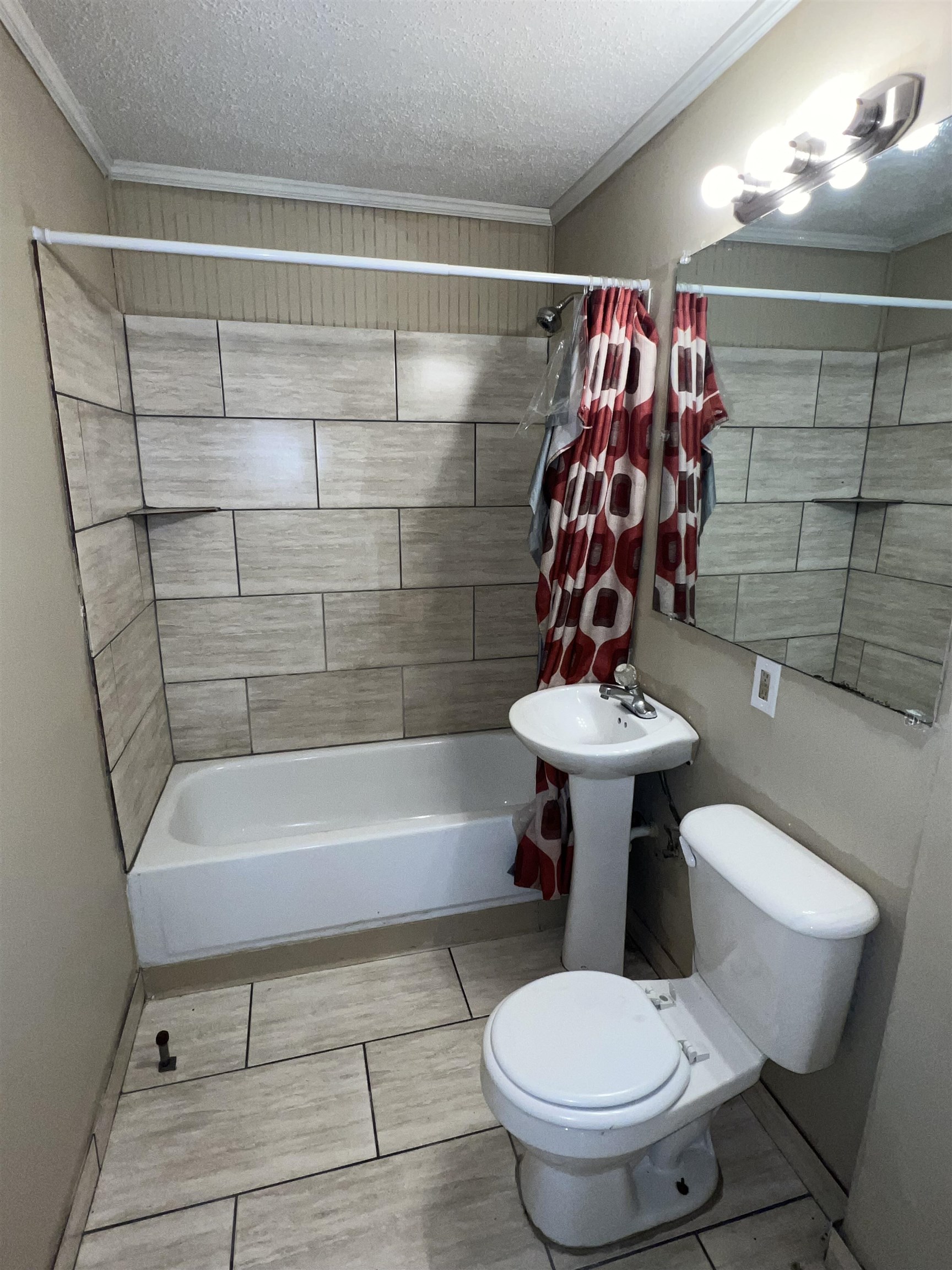 892 Restbrook Avenue Memphis, TN 38127 - Photo 6 of 11 Bathroom with a textured ceiling, shower / bathtub combination with curtain, and ornamental molding
