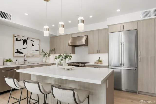 a kitchen with stainless steel appliances kitchen island granite countertop a kitchen island and chairs