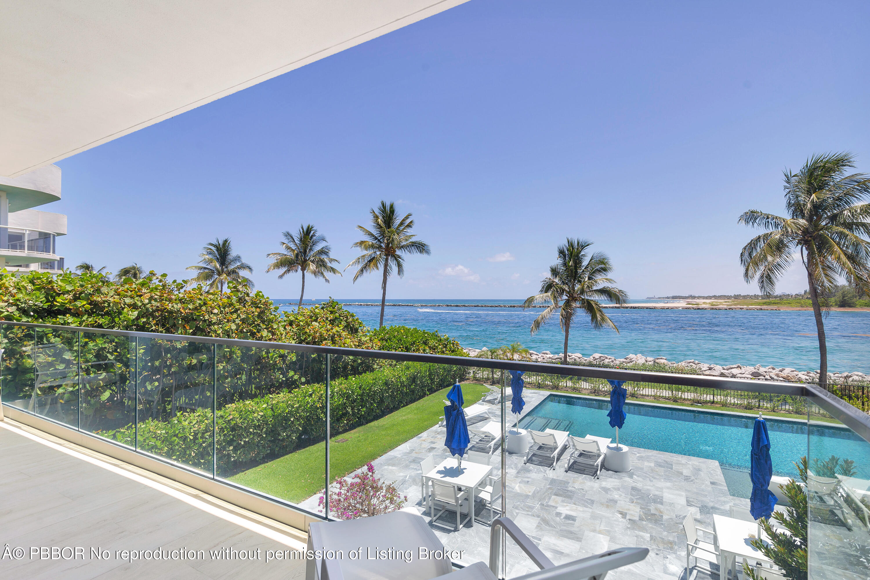 150 Inlet Way, Unit 1E Palm Beach Shores, FL 33404 - Photo 28 of 41 a view of a swimming pool with a lounge chair and palm trees