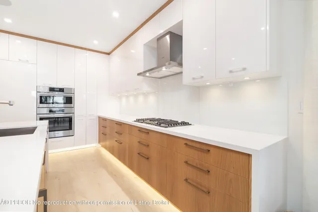 a kitchen with stainless steel appliances white cabinets and a refrigerator
