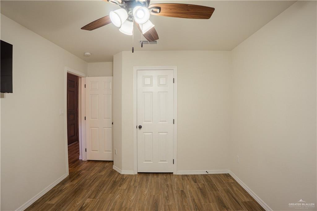8725 Spoonbill Street Harlingen, TX 78552 - Photo 5 of 18 wooden floor in an empty room with a window