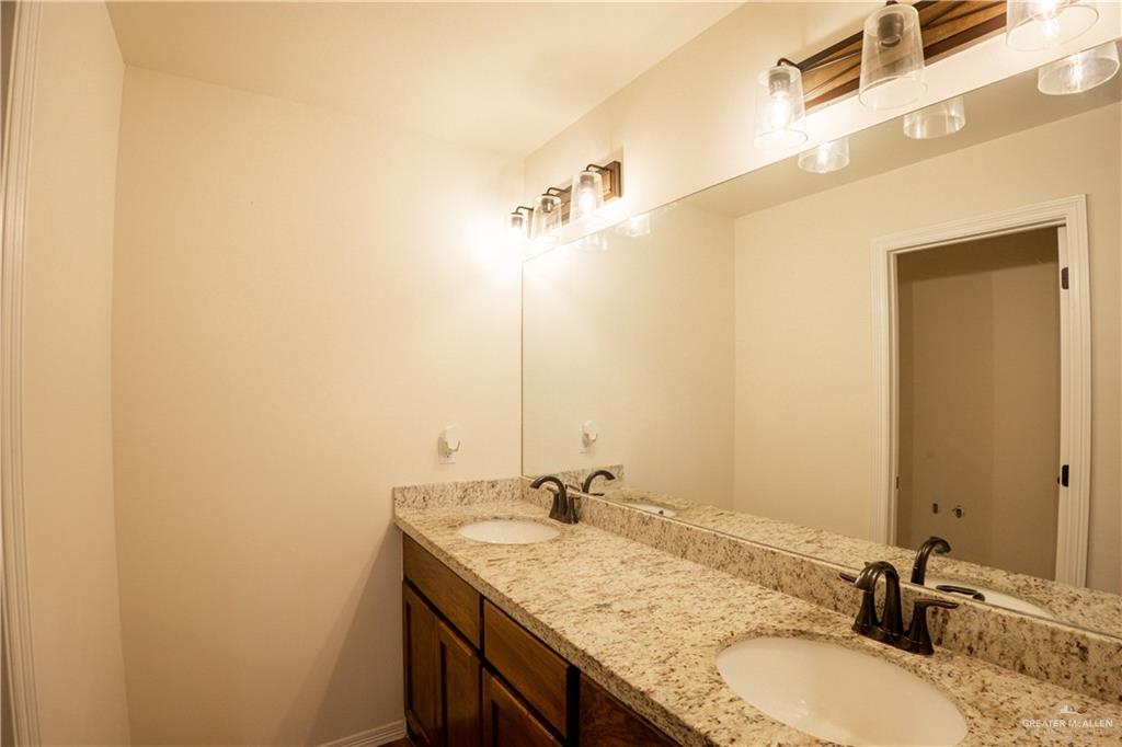 8725 Spoonbill Street Harlingen, TX 78552 - Photo 7 of 18 a bathroom with a granite countertop sink and a mirror