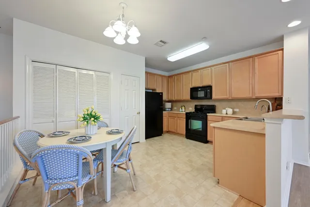 a kitchen with a refrigerator a stove a sink dishwasher with a dining table and chairs