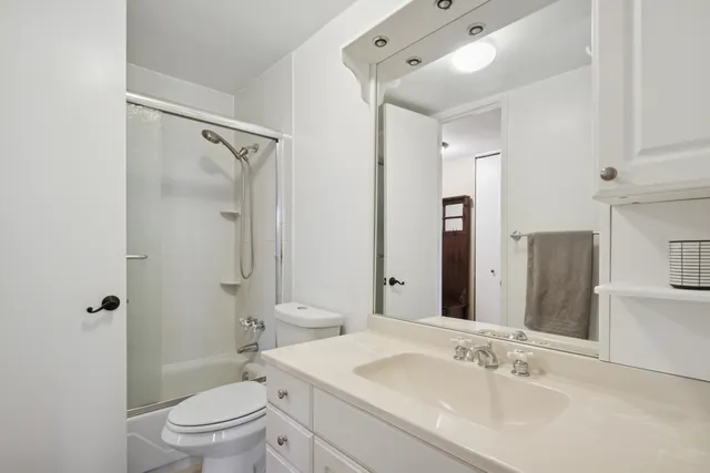 a bathroom with a sink toilet vanity and shower