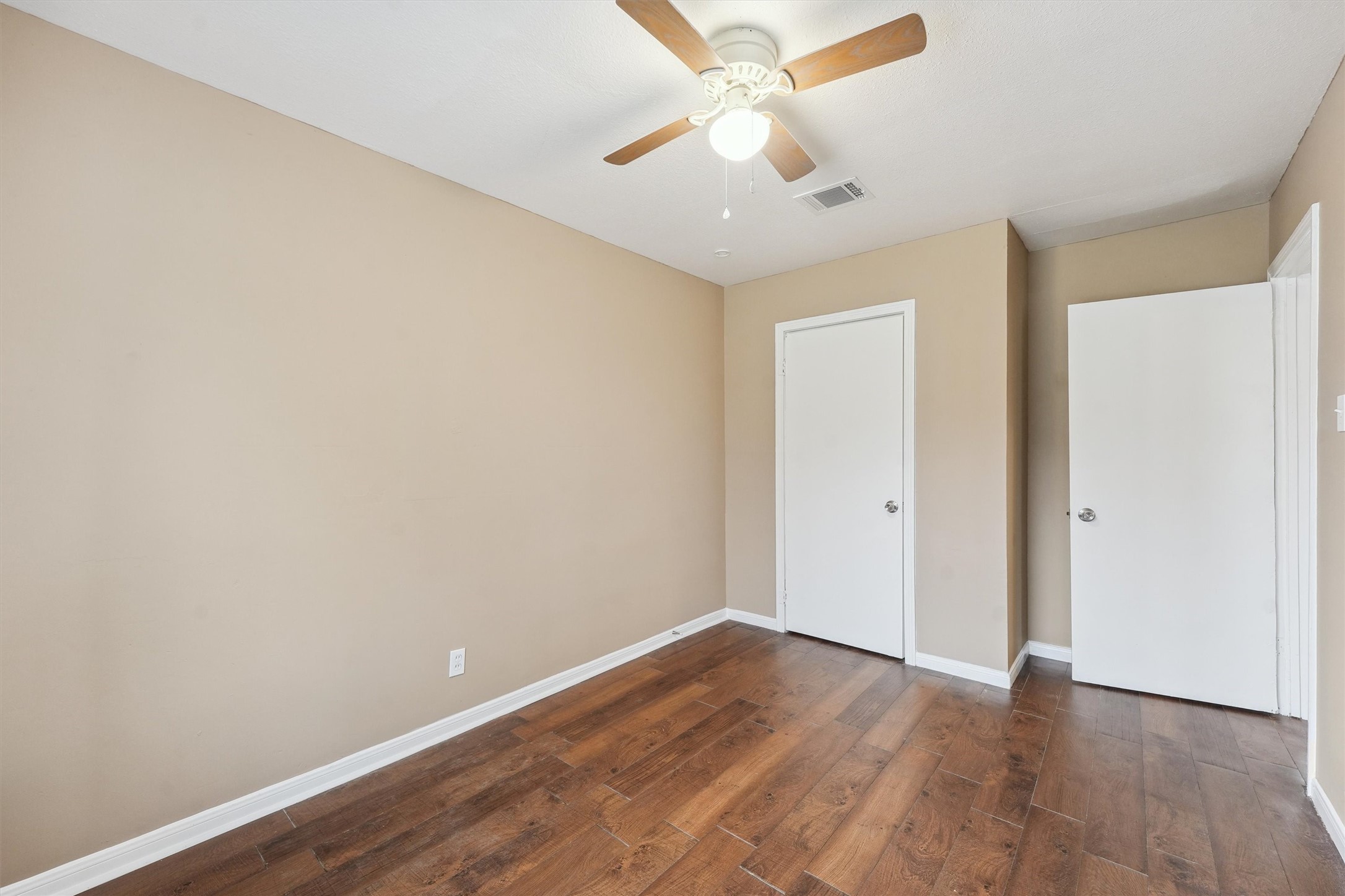 1107 Defender Street Houston, TX 77029 - Photo 18 of 26 an empty room with wooden floor and fan