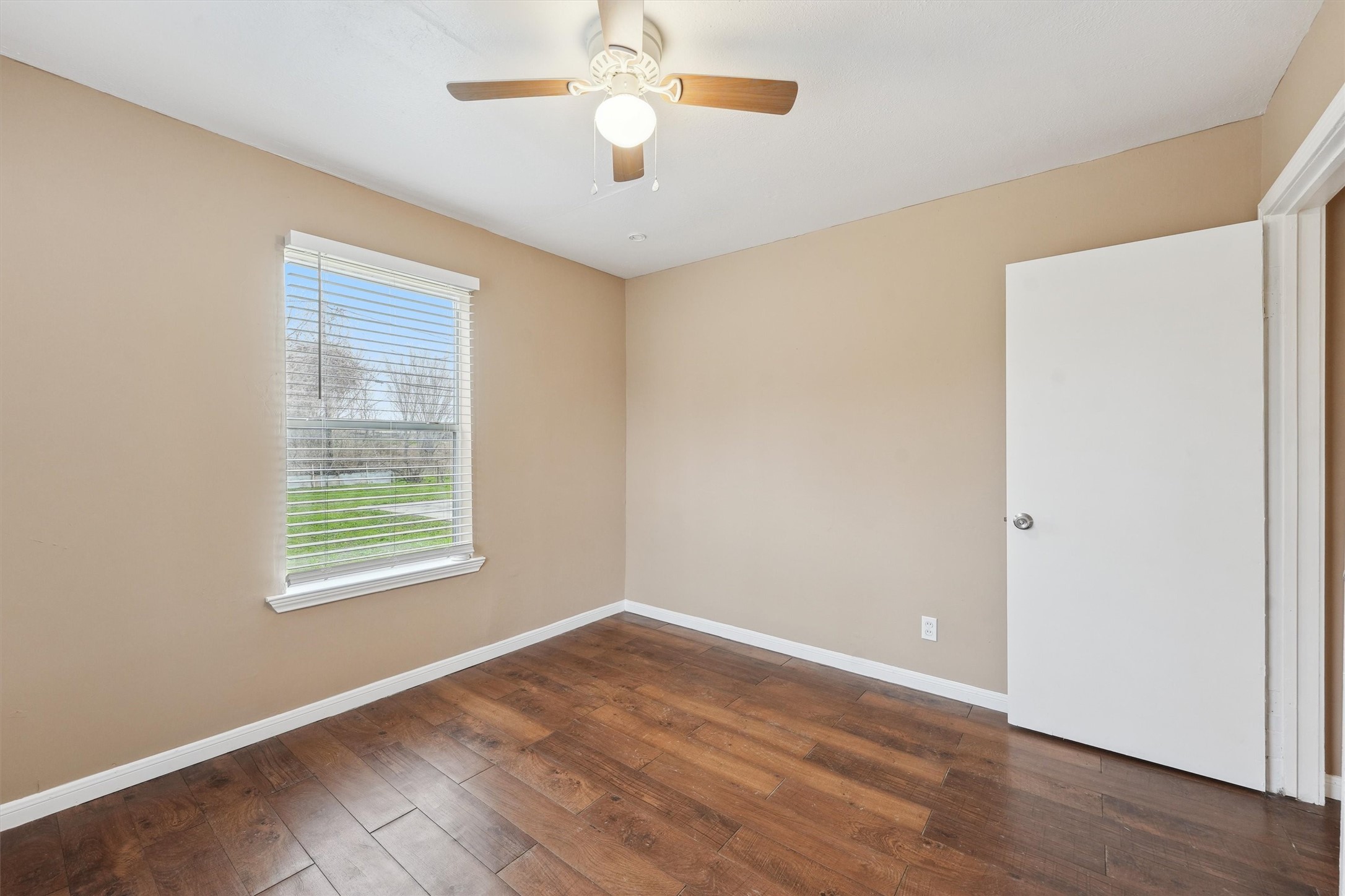 1107 Defender Street Houston, TX 77029 - Photo 21 of 26 an empty room with wooden floor chandelier fan and windows