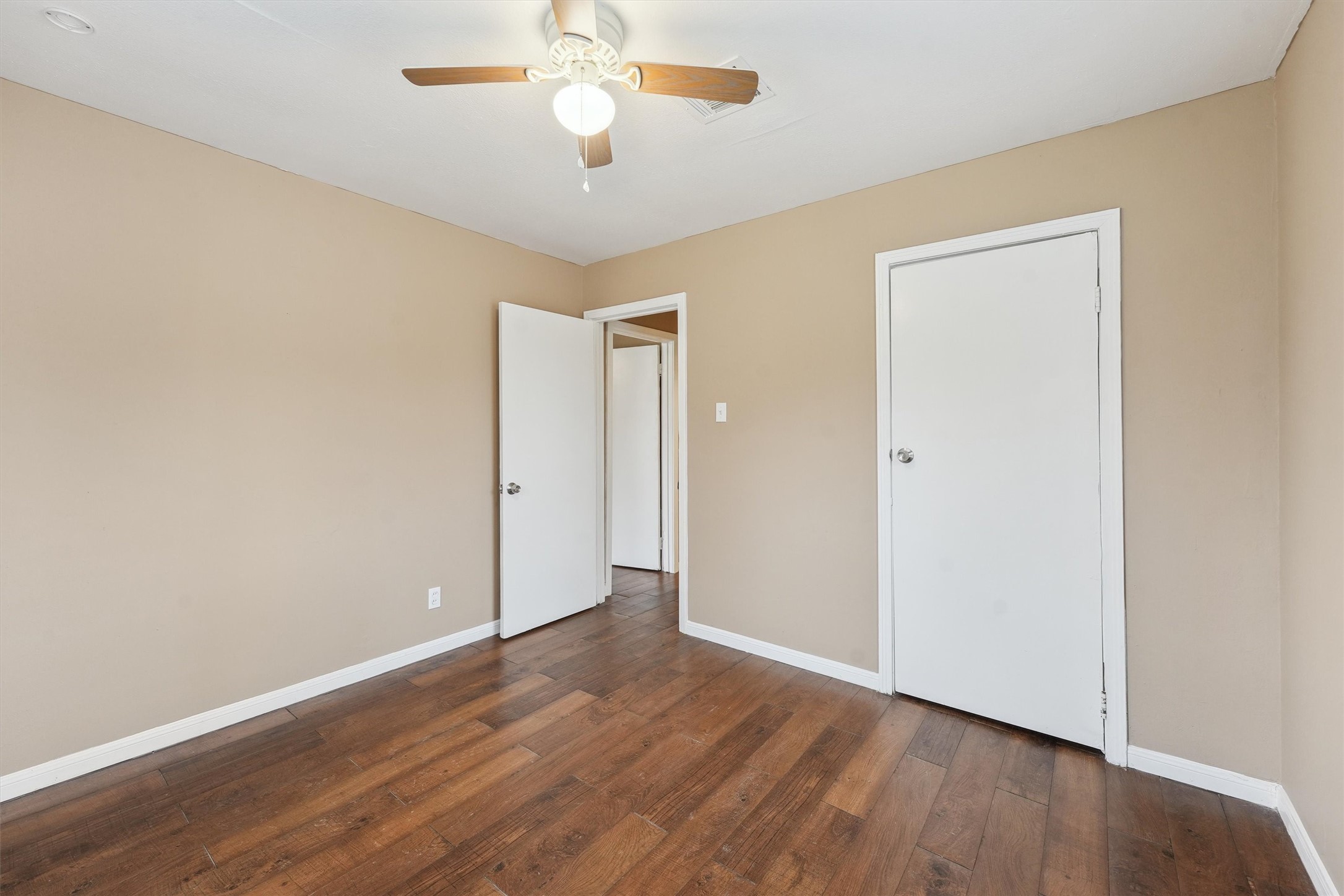 1107 Defender Street Houston, TX 77029 - Photo 22 of 26 an empty room with wooden floor and a ceiling fan