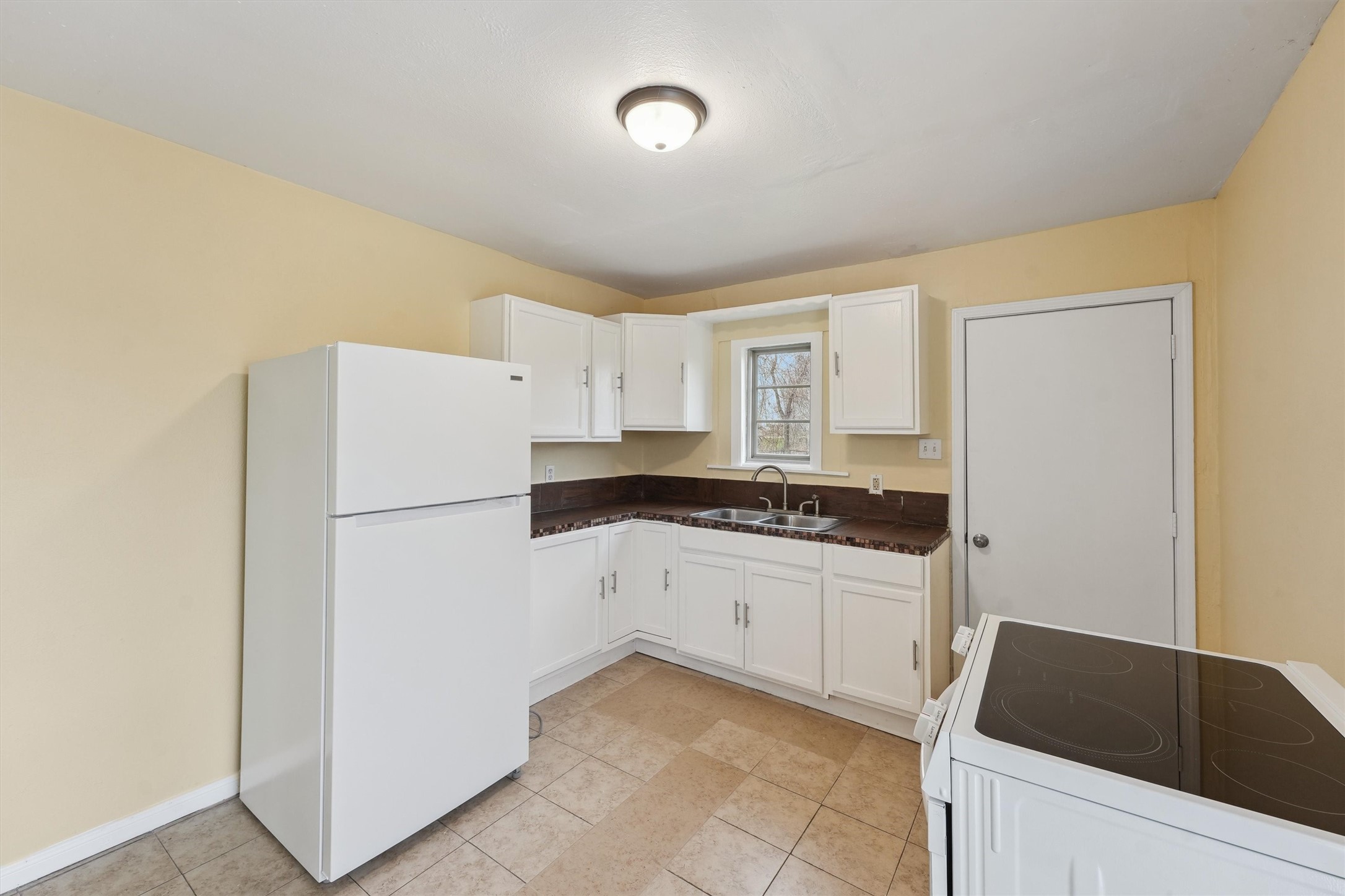 1107 Defender Street Houston, TX 77029 - Photo 9 of 26 a kitchen with a refrigerator and a sink
