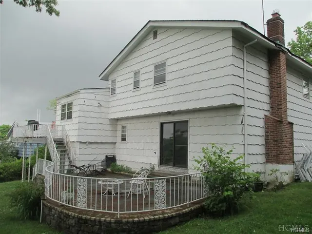 a view of a house with a small yard and deck
