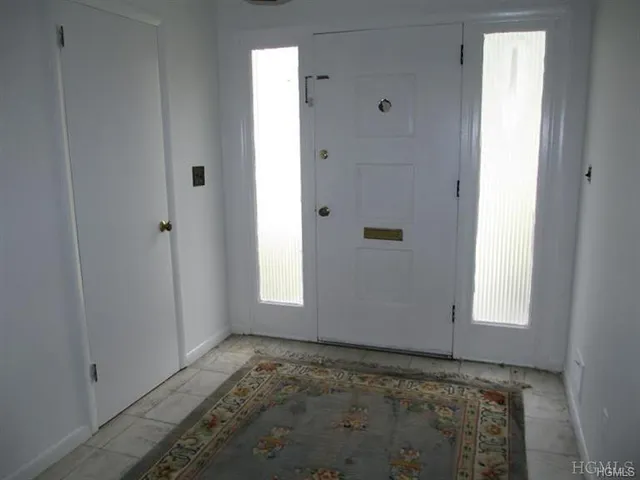 a view of a hallway with wooden floor and entryway