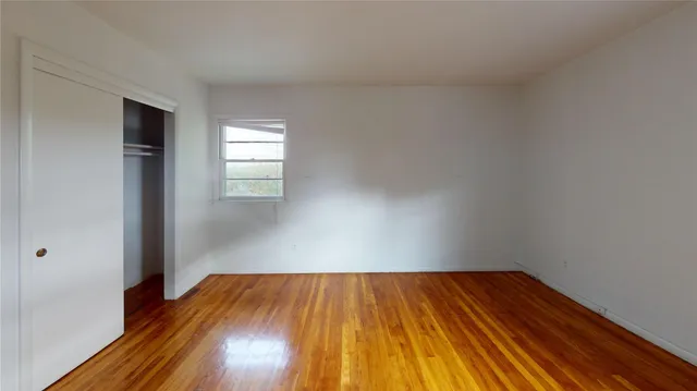 a view of empty room with window and chandelier fan