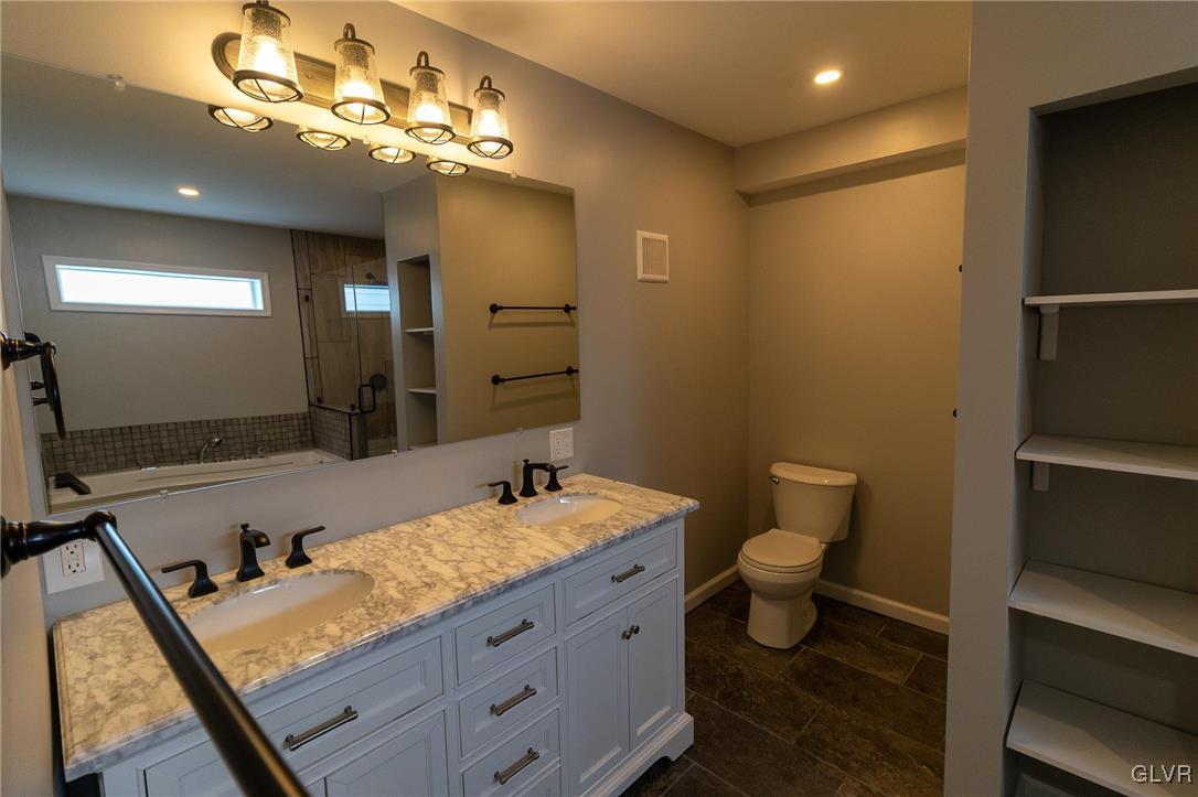 6366 Farm Bureau Road Allentown, PA 18106 - Photo 16 of 36 a bathroom with a granite countertop sink a toilet and a mirror