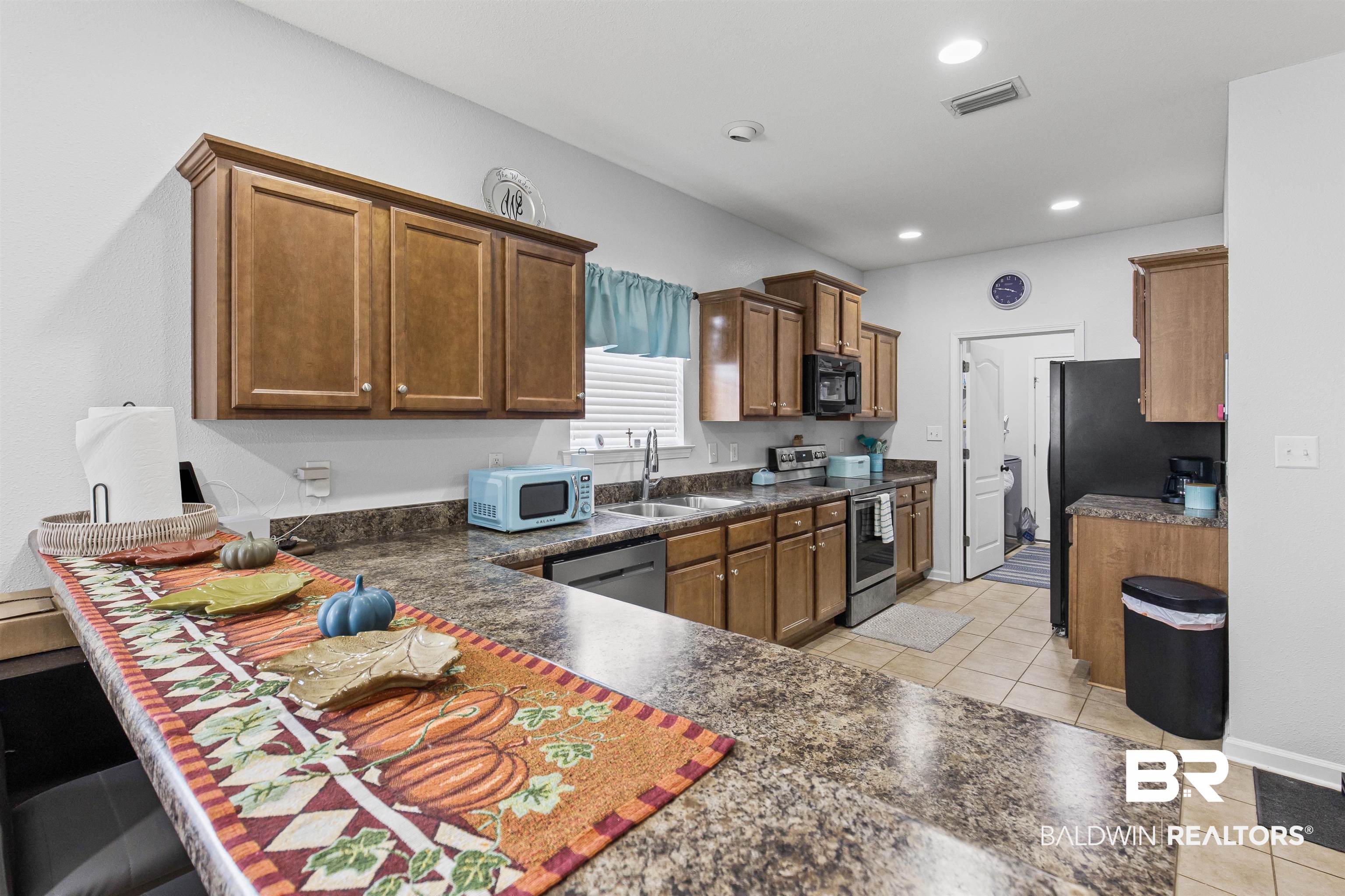 4107 Nottingham Drive Semmes, AL 36575 - Photo 4 of 23 Kitchen featuring light tile patterned flooring, stainless steel appliances, brown cabinets, and recessed lighting