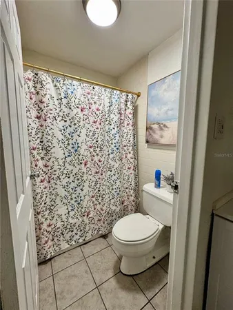a white toilet sitting next to a shower curtain