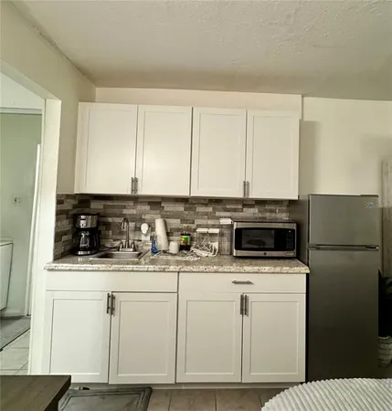 a kitchen with white cabinets sink and white appliances