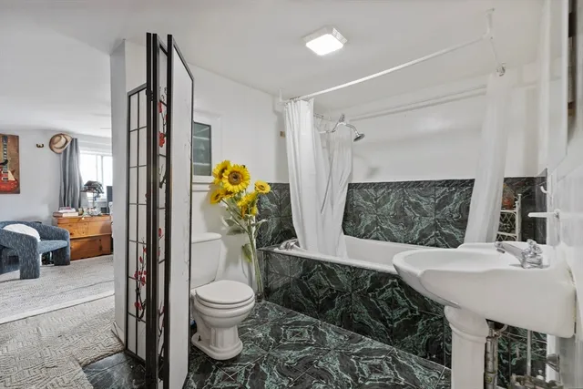 a bathroom with a sink toilet and a mirror