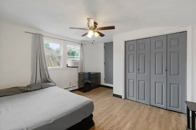 a bedroom with a bed and wooden floor