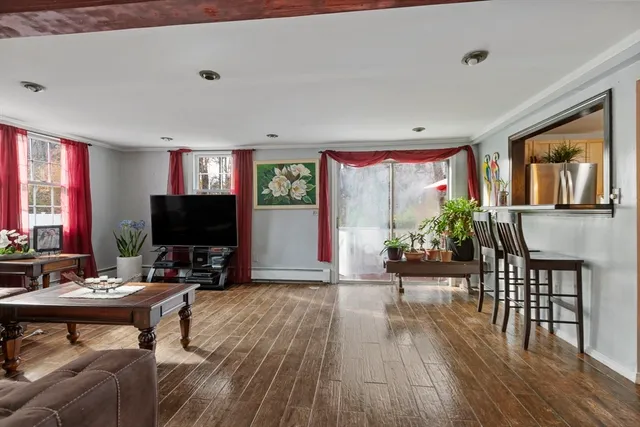 a living room with furniture a flat screen tv and a floor to ceiling window