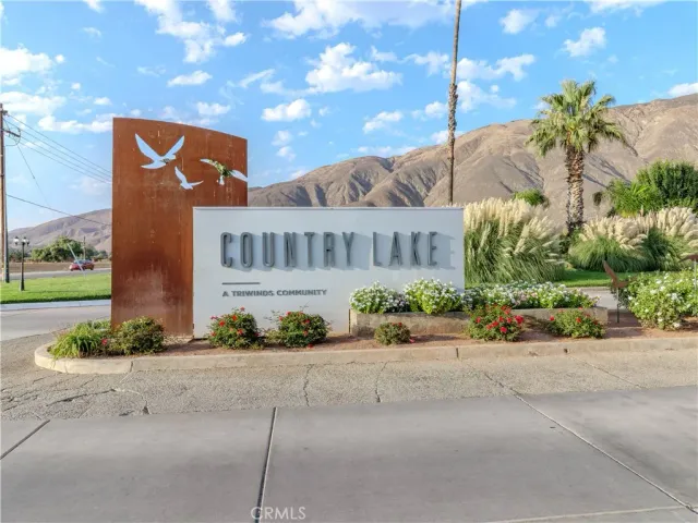 a front view of multi story residential apartment building with yard and parking