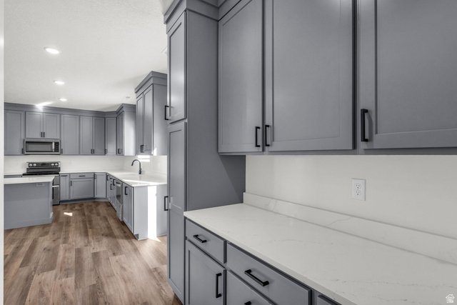 520 East 450th Street North Delta, UT 84624 - Photo 28 of 48 Kitchen featuring gray cabinetry, stainless steel appliances, light wood finished floors, light stone counters, and recessed lighting