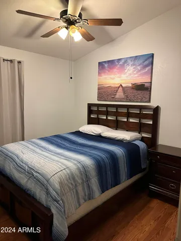 a bedroom with a bed and wooden floor
