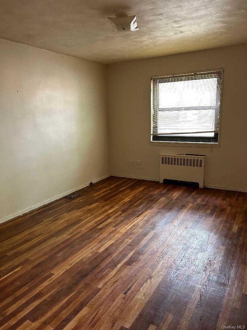 163-30 17th Avenue, Unit 4297 Queens, NY 11357 - Photo 13 of 17 an empty room with wooden floor and windows