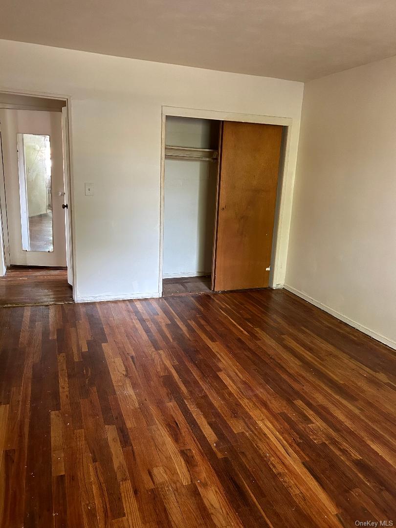163-30 17th Avenue, Unit 4297 Queens, NY 11357 - Photo 17 of 17 a view of an empty room with wooden floor and a window