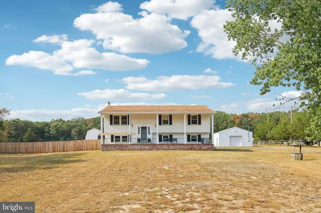 a front view of a house with a yard and lake view