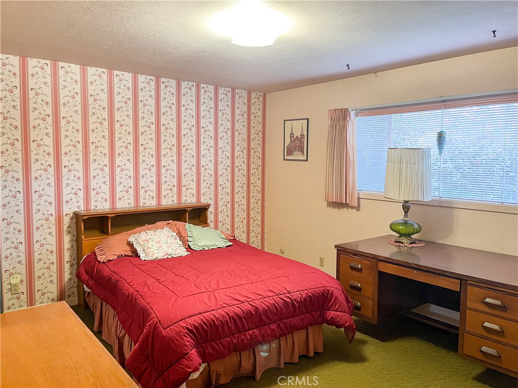 3665 Woodson Avenue Corning, CA 96021 - Photo 11 of 30 a bedroom with a bed a dresser and a window