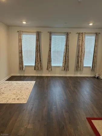 an empty room with wooden floor and window