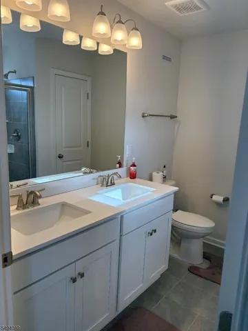 a bathroom with a sink a toilet and a mirror
