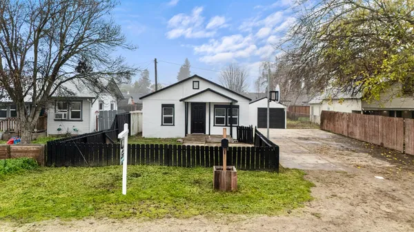 a view of house with a yard and a large tree