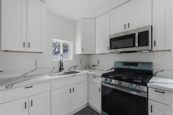a kitchen with cabinets stainless steel appliances a sink and a microwave