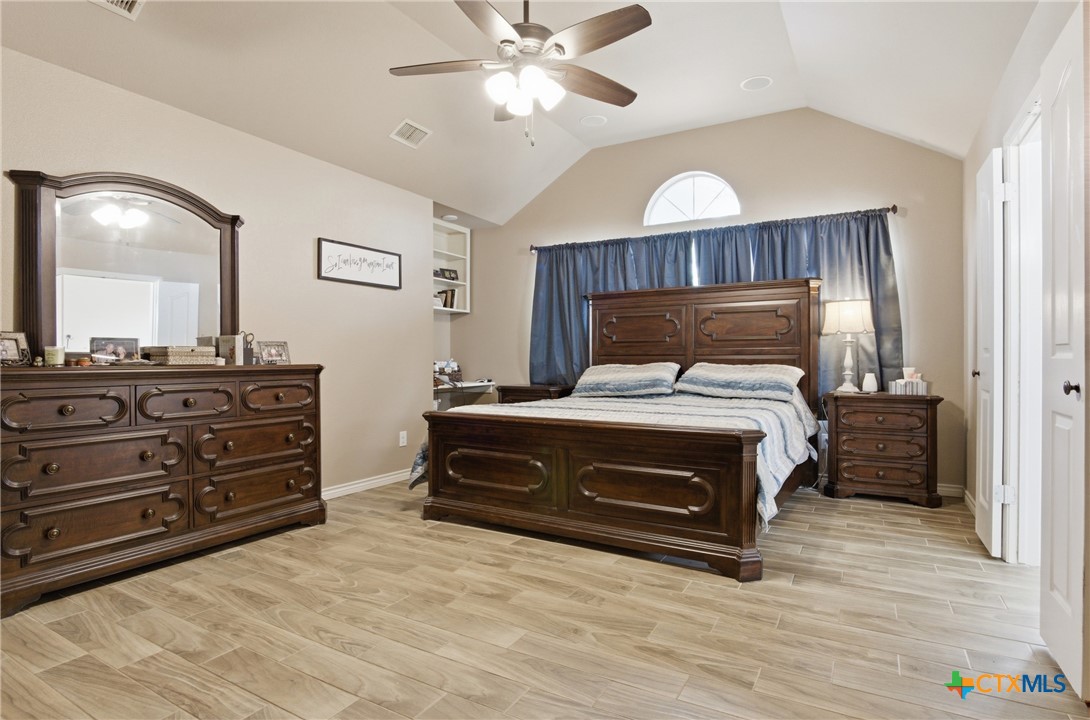 642 Phantom Rider Trail Spring Branch, TX 78070 - Photo 14 of 41 a bedroom with a bed and a chandelier