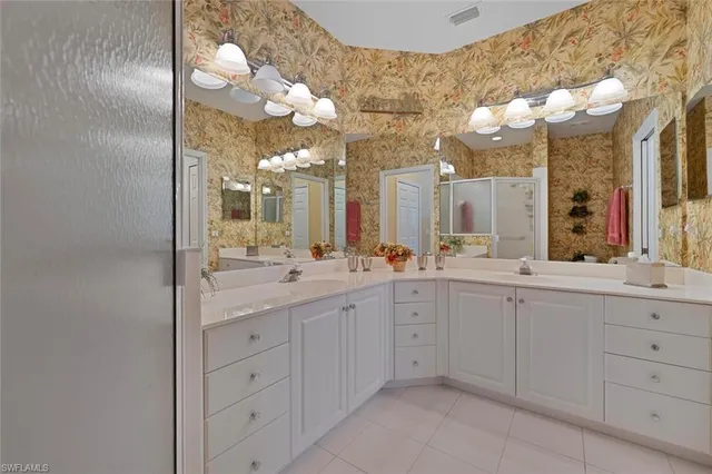 a spacious bathroom with a granite countertop sink a mirror and a shower