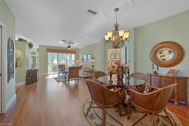a dining room with furniture a chandelier and wooden floor
