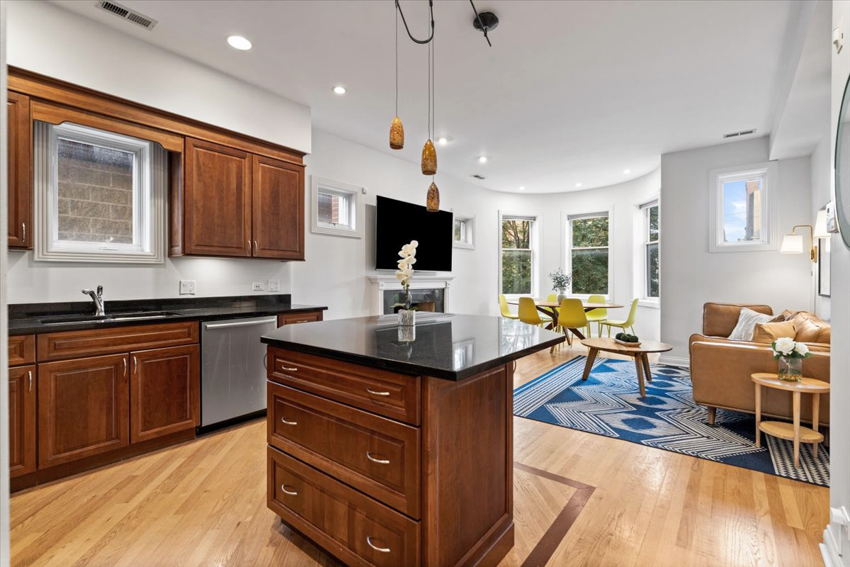 2642 North Racine Avenue, Unit 2N Chicago, IL 60614 - Photo 7 of 22 a kitchen with stainless steel appliances granite countertop a stove top oven a dining table and chairs with wooden floor