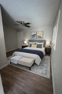 a bedroom with a bed rug and wooden floor