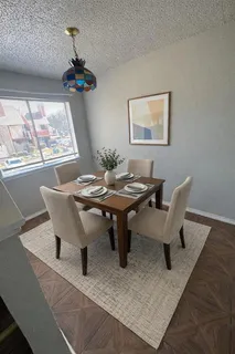 a dining room with furniture a rug and wooden floor