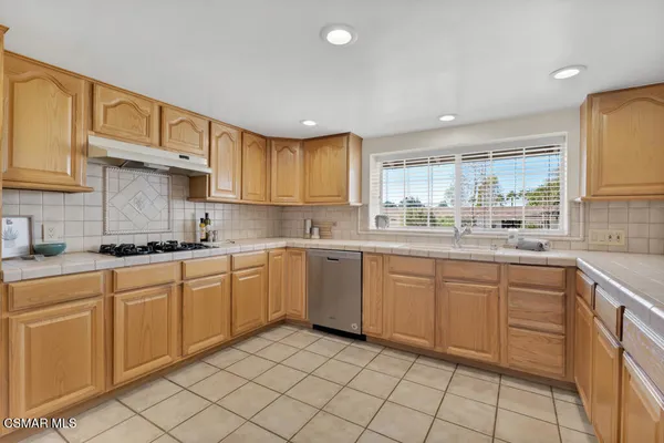 a kitchen with a sink window and cabinets