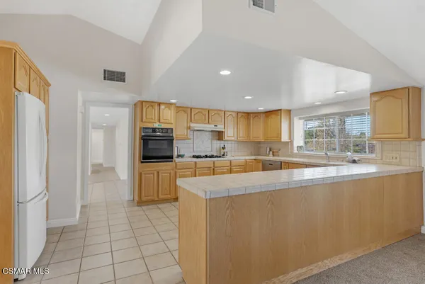 a large kitchen with a large counter top appliances and cabinets