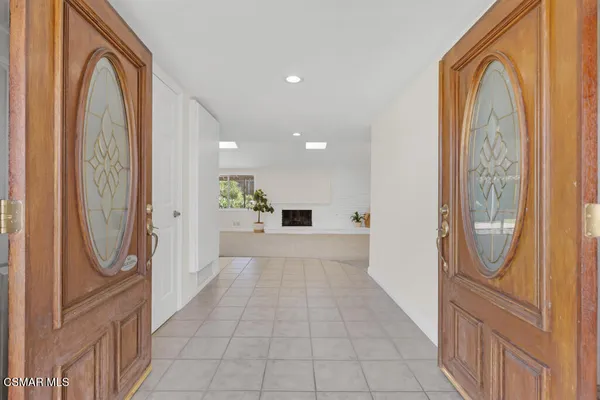 a view of a hallway with wooden floor and a bathroom