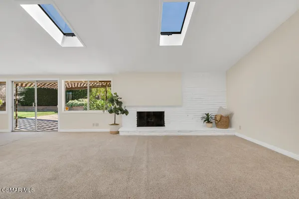 a view of an empty room with a fireplace and a large window