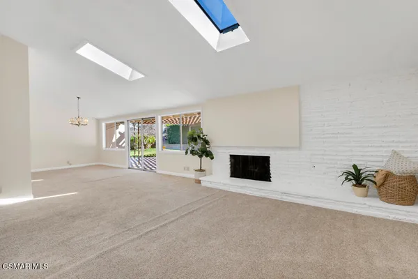 a living room with a fireplace and a potted plant